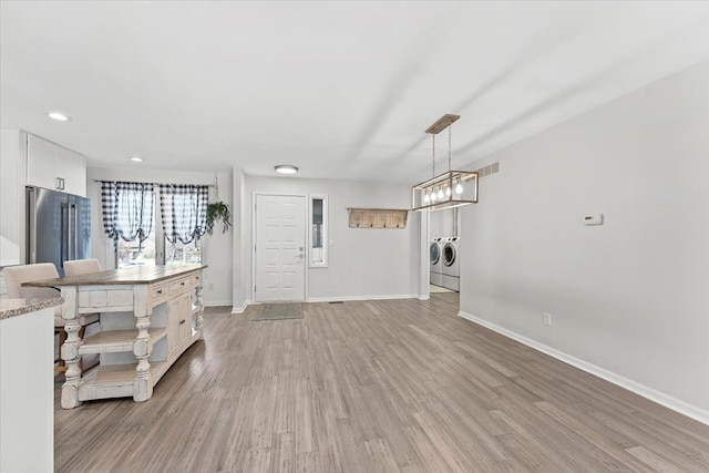 interior space with separate washer and dryer and light hardwood / wood-style floors