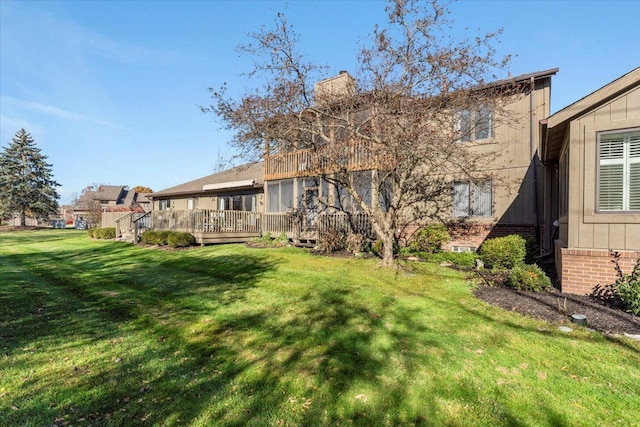 back of property with a lawn and a wooden deck