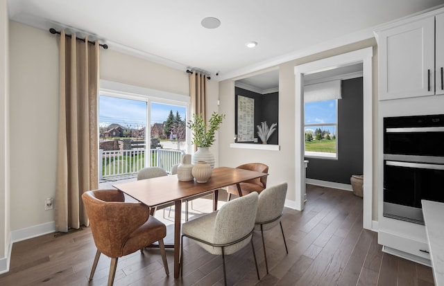 dining area featuring crown molding, a healthy amount of sunlight, and dark hardwood / wood-style flooring