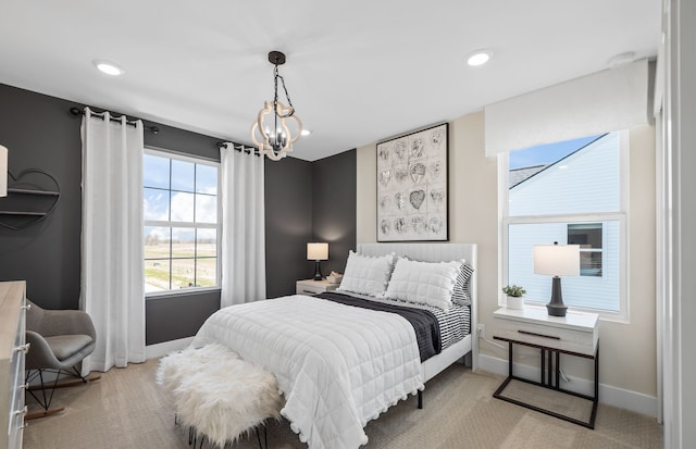 bedroom featuring an inviting chandelier and light carpet