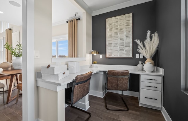 office featuring dark hardwood / wood-style flooring, crown molding, and built in desk