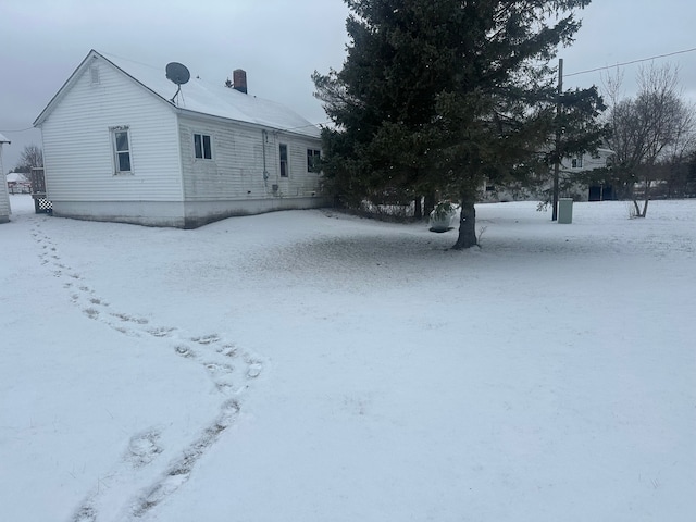 view of snow covered rear of property