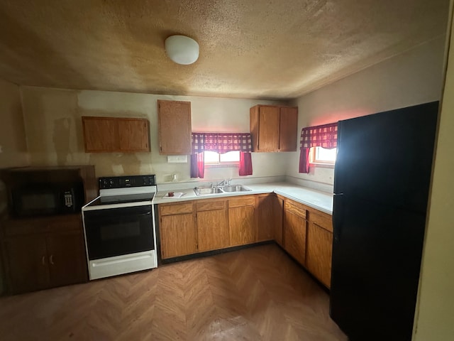 kitchen with range with electric cooktop, parquet flooring, sink, and a textured ceiling