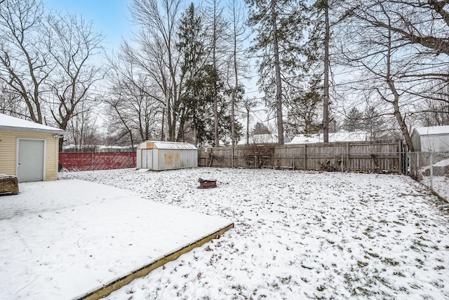 yard layered in snow featuring a storage unit