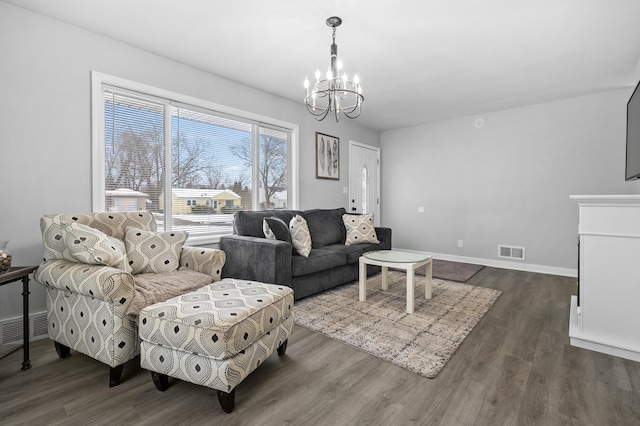 living room with a chandelier and dark hardwood / wood-style floors