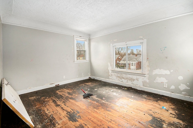 empty room featuring wood-type flooring and a textured ceiling