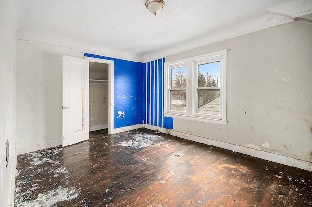 unfurnished bedroom featuring wood-type flooring and a closet