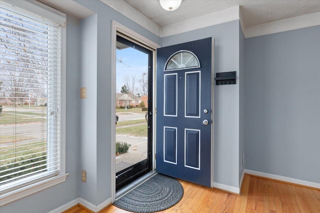 foyer entrance with hardwood / wood-style flooring and ornamental molding