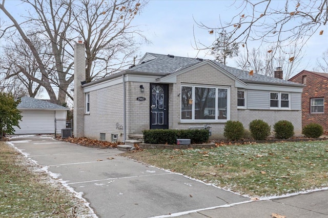 view of front of house featuring a garage, an outdoor structure, and a front lawn