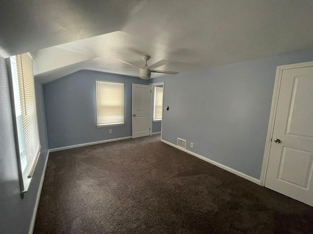 additional living space with ceiling fan, dark carpet, and lofted ceiling