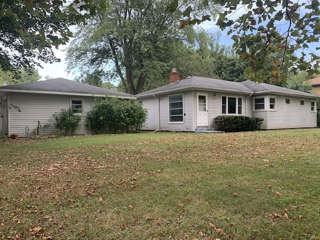 rear view of property with a lawn