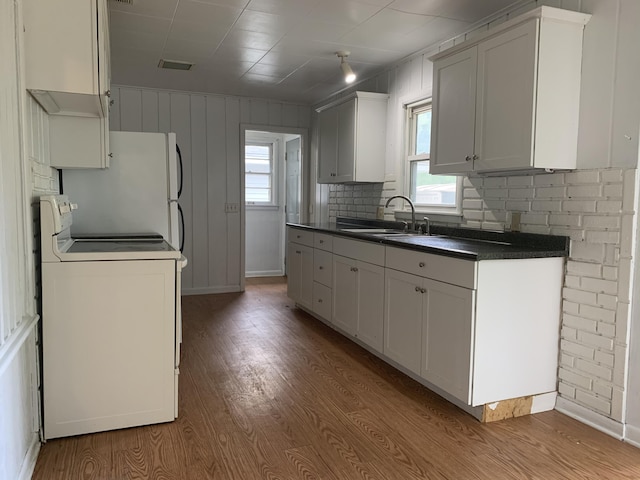 kitchen with stove, white cabinetry, plenty of natural light, and sink