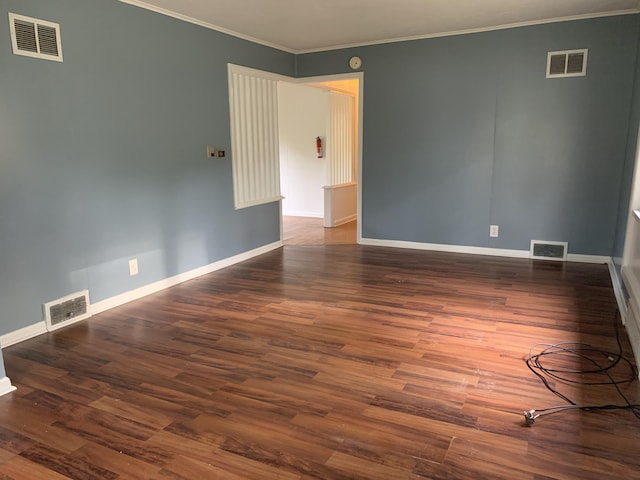 empty room featuring dark hardwood / wood-style flooring and ornamental molding