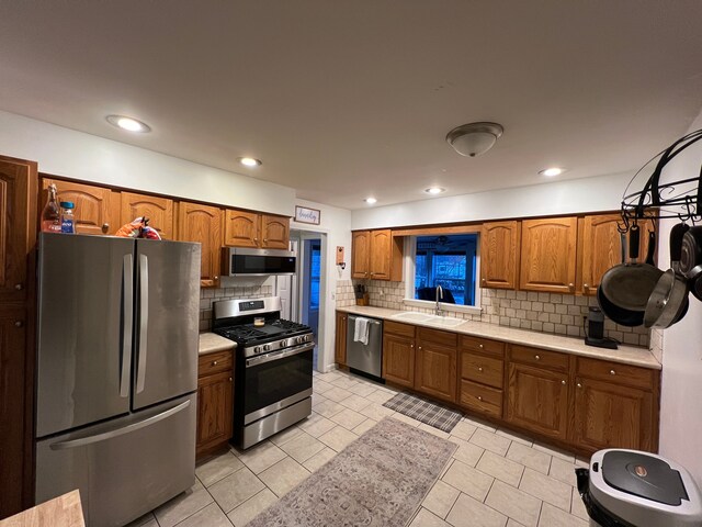 kitchen with stainless steel appliances, light tile patterned floors, sink, and tasteful backsplash