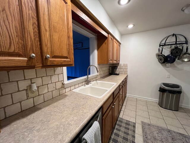 kitchen with sink, light tile patterned floors, stainless steel dishwasher, and tasteful backsplash