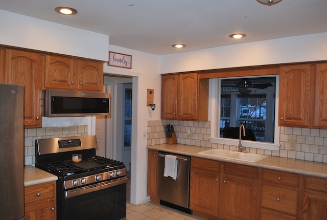 kitchen featuring stainless steel appliances, light tile patterned floors, sink, and tasteful backsplash