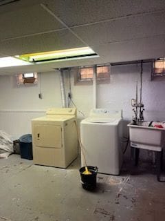 basement with washing machine and dryer and sink