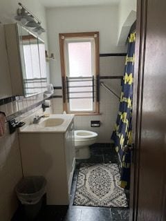 bathroom with a wealth of natural light, vanity, and toilet