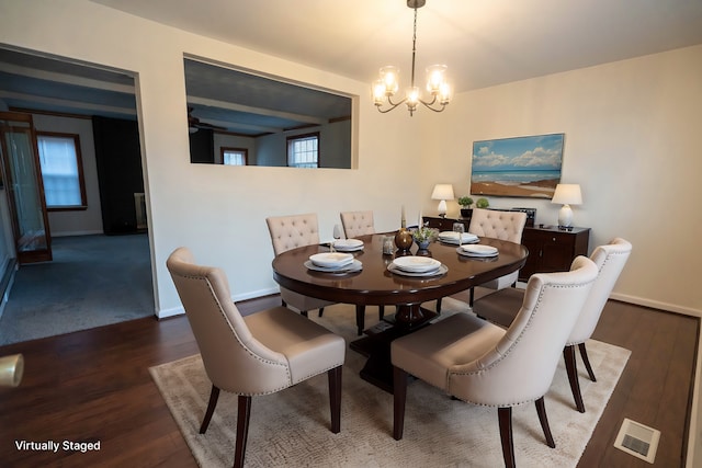 dining space featuring an inviting chandelier and dark wood-type flooring