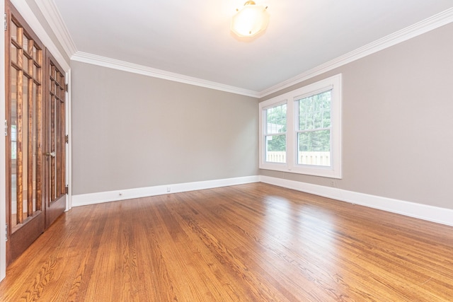 spare room featuring hardwood / wood-style flooring and ornamental molding