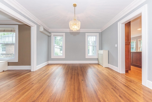 unfurnished room featuring a wall mounted air conditioner, light hardwood / wood-style flooring, crown molding, and a notable chandelier