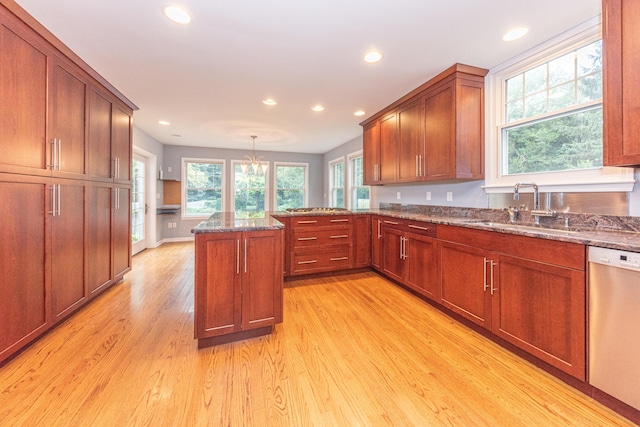 kitchen featuring dishwasher, sink, an inviting chandelier, light hardwood / wood-style floors, and pendant lighting