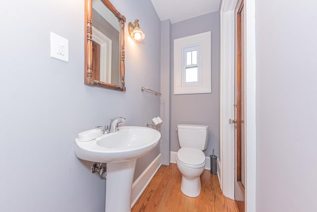 bathroom featuring wood-type flooring and toilet