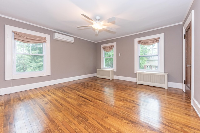 unfurnished bedroom featuring radiator, ceiling fan, hardwood / wood-style floors, and a wall mounted air conditioner