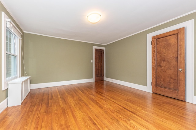 empty room featuring light hardwood / wood-style flooring and ornamental molding