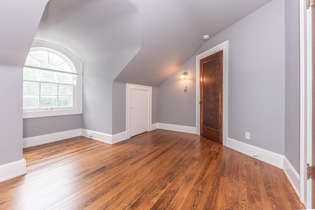 additional living space with dark hardwood / wood-style flooring and lofted ceiling