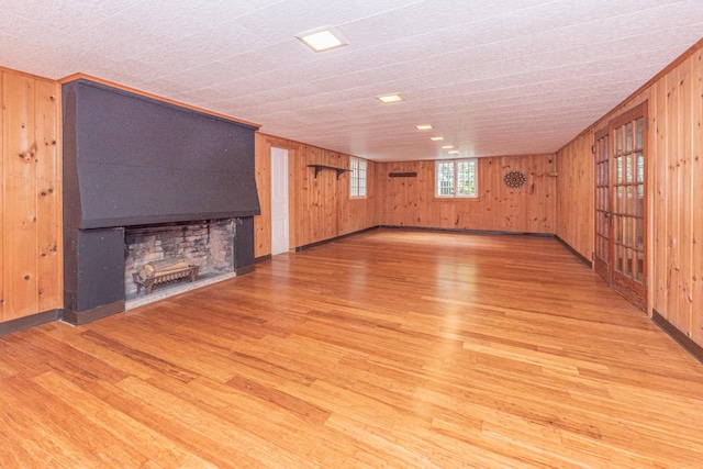 unfurnished living room with wood-type flooring and wood walls