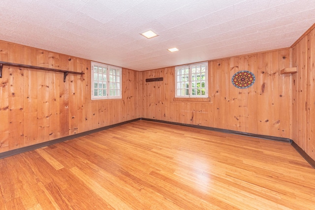 spare room featuring wood walls and light hardwood / wood-style flooring