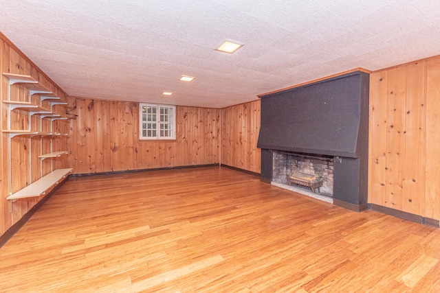 basement with wood walls and hardwood / wood-style flooring