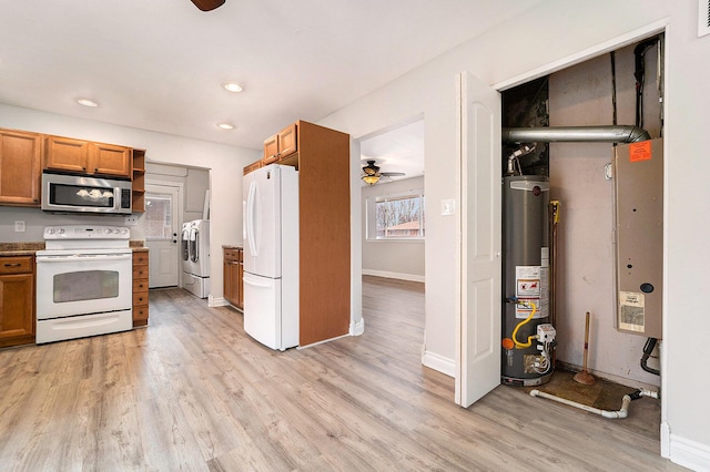 kitchen with ceiling fan, water heater, independent washer and dryer, light hardwood / wood-style floors, and white appliances