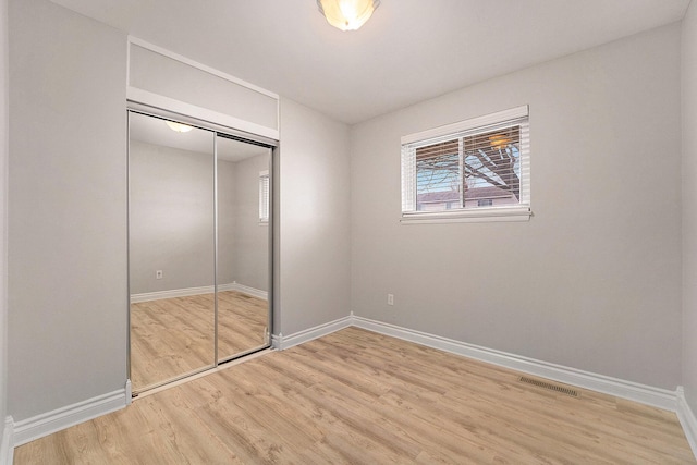 unfurnished bedroom featuring hardwood / wood-style floors and a closet