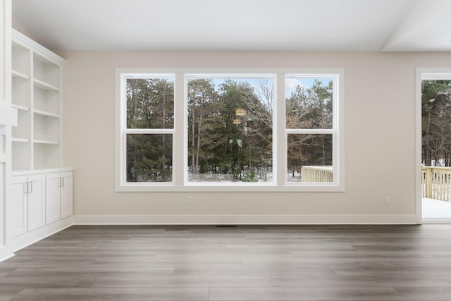 interior space featuring built in shelves, dark hardwood / wood-style floors, and lofted ceiling