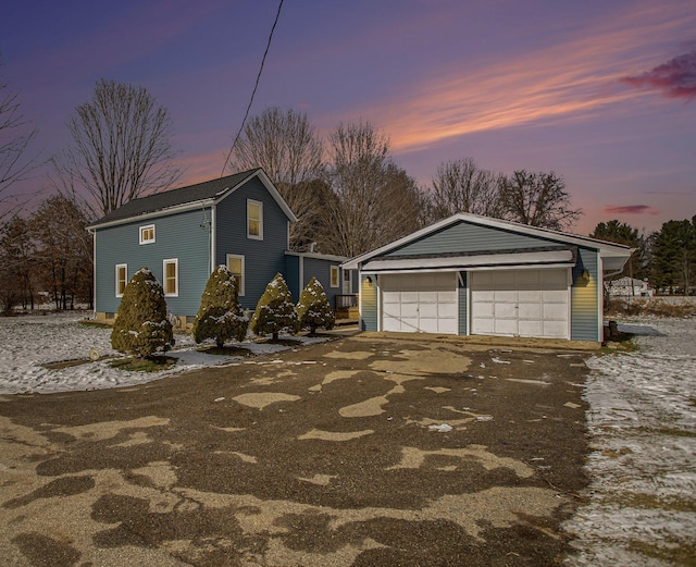 property exterior at dusk with a garage and an outdoor structure