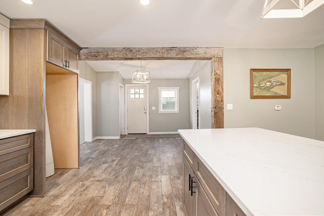 kitchen featuring hardwood / wood-style flooring, decorative light fixtures, and beam ceiling