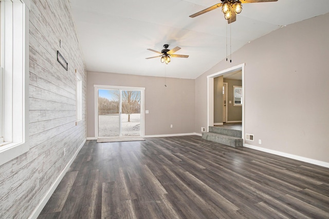 unfurnished living room featuring dark hardwood / wood-style floors, ceiling fan, and vaulted ceiling