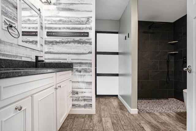 bathroom with a tile shower and vanity