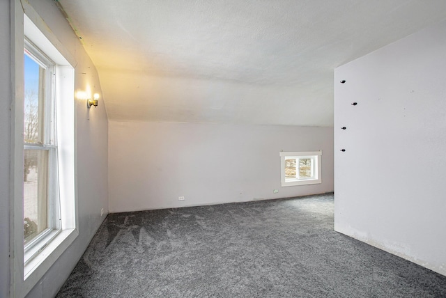 carpeted empty room featuring vaulted ceiling