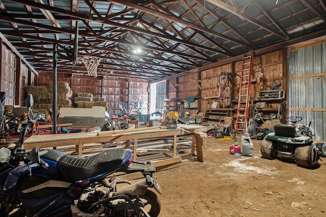 miscellaneous room with a workshop area, lofted ceiling, and concrete flooring