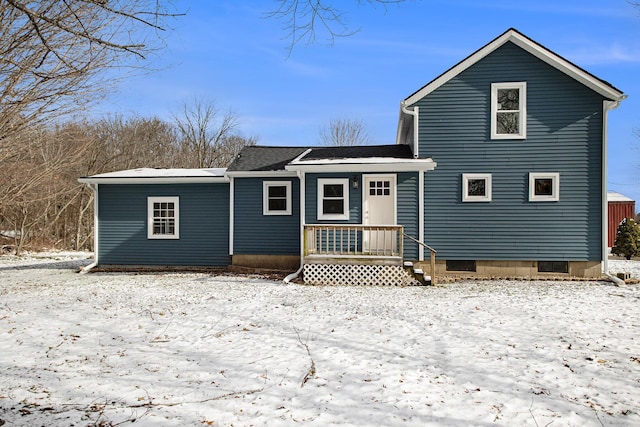 view of snow covered back of property