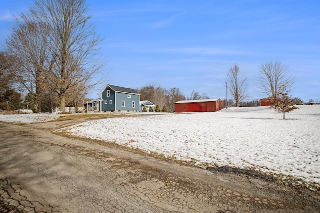 yard layered in snow with an outbuilding