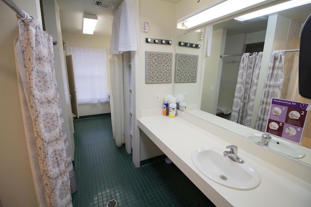 bathroom with curtained shower, tile patterned flooring, and vanity