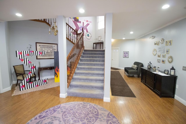 stairway with wood-type flooring and crown molding