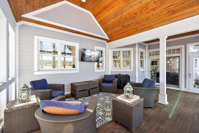 interior space featuring lofted ceiling, dark wood-type flooring, wooden walls, wood ceiling, and decorative columns