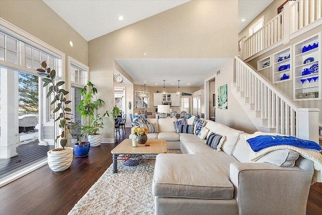 living room featuring dark hardwood / wood-style floors, a healthy amount of sunlight, and high vaulted ceiling