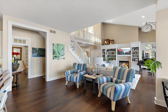 living room featuring a stone fireplace and dark wood-type flooring