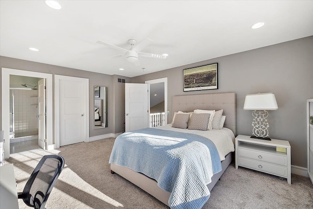 bedroom with connected bathroom, light colored carpet, and ceiling fan